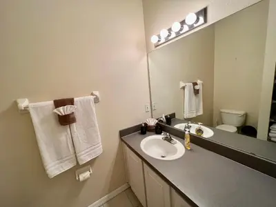 a bathroom with a sink and a mirror at Grand Deluxe 3BR Townhouse near Disney Parks in Kissimmee