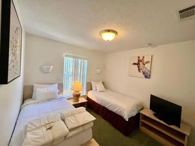 a hotel room with two beds and a television at Grand Deluxe 3BR Townhouse near Disney Parks in Kissimmee