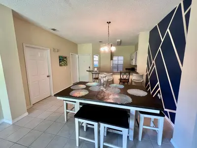 a kitchen and dining room with a table and chairs at Grand Deluxe 3BR Townhouse near Disney Parks in Kissimmee