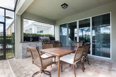 a dining room with a wooden table and chairs at Fantabulous Disney Vacation House in Orlando
