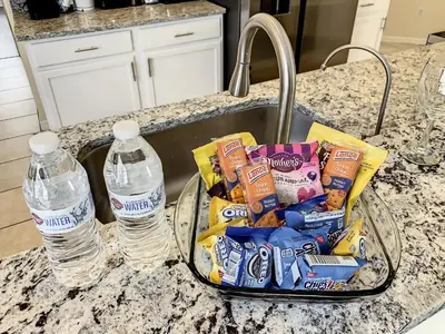 a tray of snacks and two water bottles on a counter at Family pool home near Disney wBBQ grill in Orlando