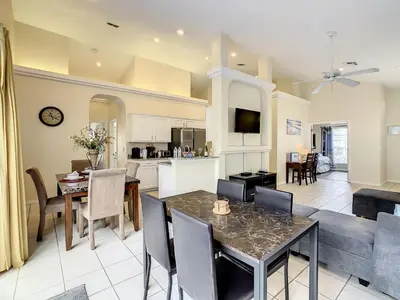 a kitchen and living room with a table and chairs at Family pool home near Disney wBBQ grill in Orlando