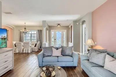 a living room with a blue couch and a table at The Marvel Mansion 5BR Pool Home Near Disney World in Orlando