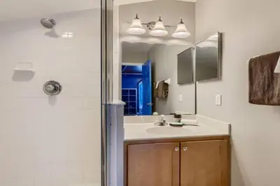 a bathroom with a sink and a shower with a mirror at The Marvel Mansion 5BR Pool Home Near Disney World in Orlando
