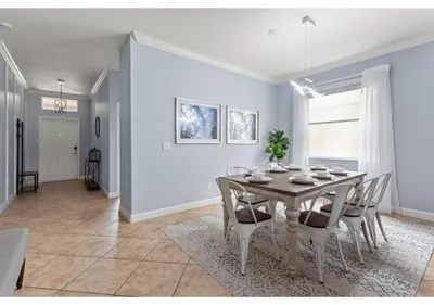 a dining room and living room with a table and chairs at Lakefront 5BR Resort Pool Home Near Disney World in Kissimmee