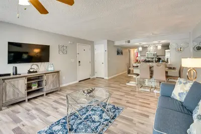 a living room with a blue couch and a kitchen at Kissimmee Vacation Rental - 5 Mi to Disney World! in Kissimmee