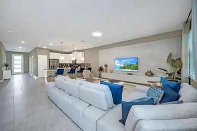 a living room with a large couch and blue pillows at 9 Bedrooms 5 Bathrooms Storey Lake 2854 Bd in Kissimmee