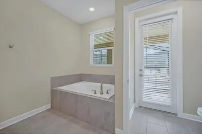 a bathroom with a tub and a window at 9 Bedrooms 5 Bathrooms Storey Lake 2854 Bd in Kissimmee