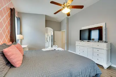 a bedroom with a bed with a ceiling fan and a tv at Kissimmee Vacation Rental with Pool about 4 Mi to Disney in Kissimmee