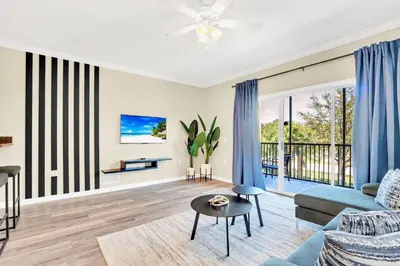 a living room with a couch and a table at 2BR Condo - Pool & Games - Near Disney in Orlando
