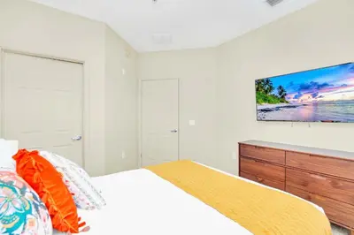 a bedroom with a bed and a tv on the wall at 3BR Condo - Pool Sauna - Near Disney in Orlando