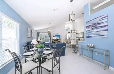 a dining room and living room with a table and chairs at Relaxing, Private Family Home At Lake Berkley Resort, South Facing Pool, Near Disney, SeaWorld in Kissimmee