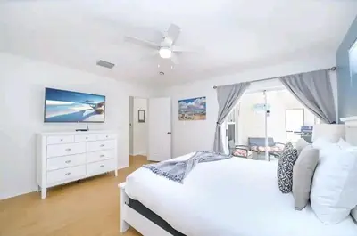 a bedroom with a white bed and a ceiling fan at Relaxing, Private Family Home At Lake Berkley Resort, South Facing Pool, Near Disney, SeaWorld in Kissimmee