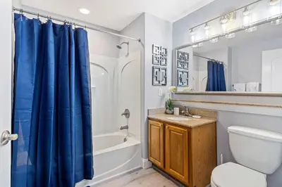 a bathroom with a blue shower curtain and a toilet at Blue Heron Beach Resort in Orlando