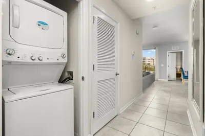 a kitchen with a washer and dryer and a hallway at Magic Condo 3BR at Storey Lake – 10 min to Disney in Kissimmee