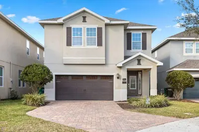 a large house with a garage in front of it at Multiple Family Homes - 23 Rooms PoolsSpas in Orlando