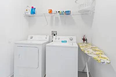 a white laundry room with two washing machines and a blanket at The Pink House at Windsor Hills in Orlando