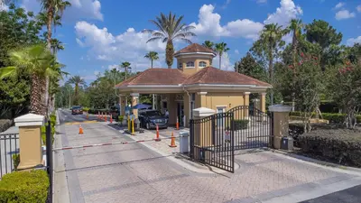 a building with a gate in front of a parking lot at The Pink House at Windsor Hills in Orlando