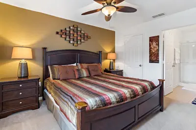 a bedroom with a bed and a ceiling fan at The Pink House at Windsor Hills in Orlando
