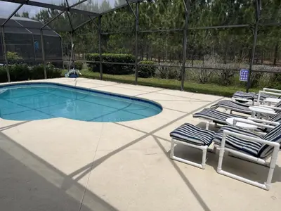 a group of lawn chairs and a swimming pool at Rise & Shine! in Orlando