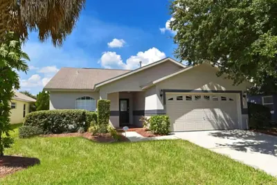 a white house with a garage at Rise & Shine! in Orlando