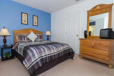 a bedroom with a bed and a dresser and a tv at Home With A View! in Orlando