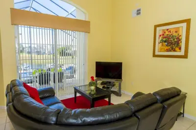 a living room with a leather couch and a table at Home With A View! in Orlando