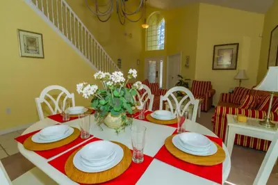 a dining room with a white table with red and white plates at Home With A View! in Orlando