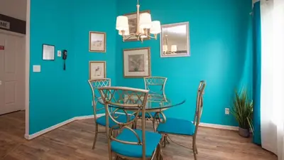 a dining room with a blue wall and a table and chairs at Just Wanna Have Sun! in Orlando