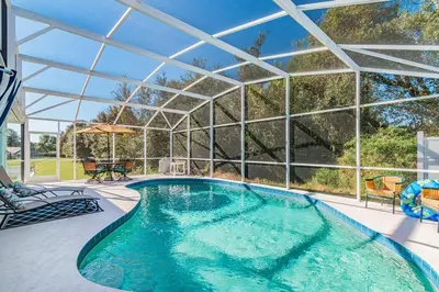 an indoor swimming pool with a large glass roof at THIS IS PARADISE FOUND! Private In-Ground Pool Home, Views, Near Dis, NO Steps, LOW Rates! in Kissimmee