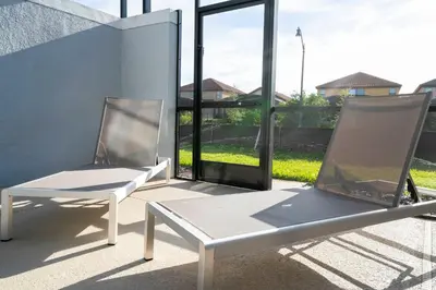 two white chairs sitting next to a wall at Brand new fantastic home at Storey lake (SL4447) in Kissimmee
