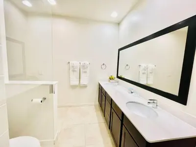 a white bathroom with a sink and a mirror at AMAZING vacation house .Mins to Disney Regal oasks in Orlando