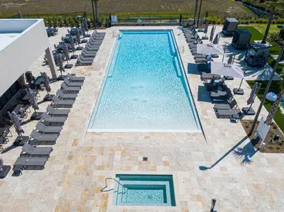an overhead view of a swimming pool with chaises and chairs at Modern and Luxury 4 suites close to Disney 7544 in Orlando