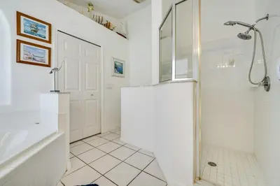 a white bathroom with a shower and a tub at 4 Mi to Disney Family Getaway with Game Room! in Kissimmee