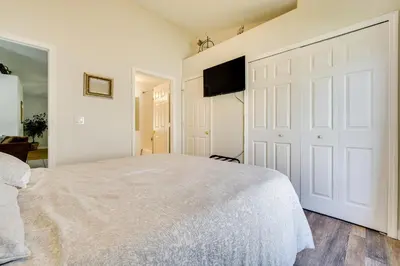 a bedroom with a white bed and a flat screen tv at 4 Mi to Disney Family Getaway with Game Room! in Kissimmee