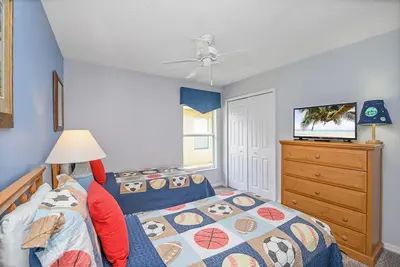 a bedroom with a bed and a tv and a dresser at Cozy Private Home at Terra Verde Resort, South Facing Pool Spa, Near Disney, SeaWorld in Kissimmee