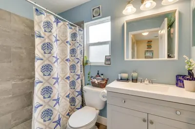 a bathroom with a toilet and a sink and a mirror at 25 Mi to Disney Home with Shared Pool in Orlando in Orlando