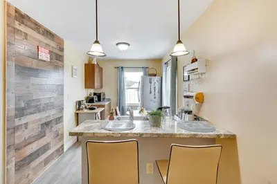 a kitchen with two sinks and two yellow chairs at 25 Mi to Disney Home with Shared Pool in Orlando in Orlando