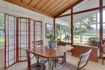 a dining room with a table and chairs and windows at Near Kayak Launch Riverfront Home in Sanford! in Sanford