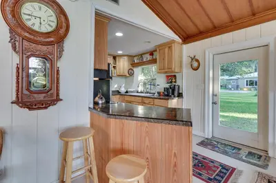 a kitchen with a large clock on the wall at Near Kayak Launch Riverfront Home in Sanford! in Sanford
