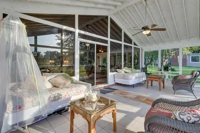 a porch with a bed and a living room at Near Kayak Launch Riverfront Home in Sanford! in Sanford