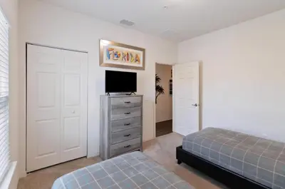 a bedroom with a bed and a tv on a dresser at 43 Townhouse Near Disney!! in Kissimmee
