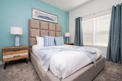a bedroom with a large bed with blue walls at Marvelous 4Bd with Pool at Storey Lake Resort 2601 in Kissimmee