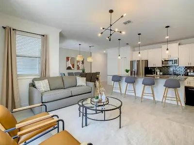 a living room with a couch and a table at 4BR Townhouse with Private Pool near Disney in Kissimmee