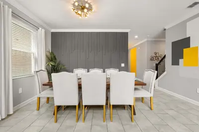 a dining room with a table and white chairs at Upstay Modern 5BR Resort Home w Pool & Hot Tub in Kissimmee