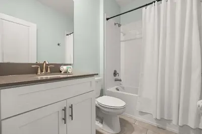 a white bathroom with a sink and a toilet at Upstay Modern 5BR Resort Home w Pool & Hot Tub in Kissimmee