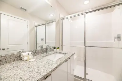 a white bathroom with a sink and a shower at 7988 Magical 5BD Home Perfect Disney Retreat in Kissimmee
