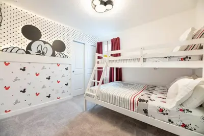 a white bedroom with a bunk bed and a crib at 7988 Magical 5BD Home Perfect Disney Retreat in Kissimmee