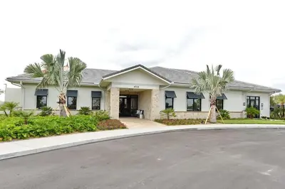 a house with palm trees in front of a driveway at 2941 Modern Four Bedroom Locate at Storey Lake in Kissimmee
