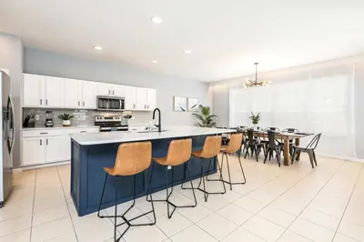 a kitchen and dining room with a large island in the middle at Family Retreat 6BR Villa with Private Pool, Spa & Theater near Disney in Kissimmee